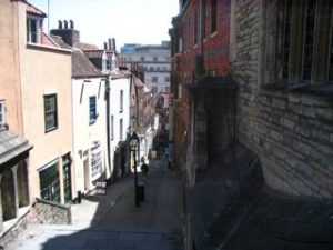 A narrow street, with steps going down a hill.