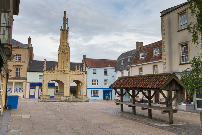 A color photograph of Shepton Mallet with Market cross, a medieval octagonal structure, in the background, and the shambles, medieval stalls for selling goods, in the foreground