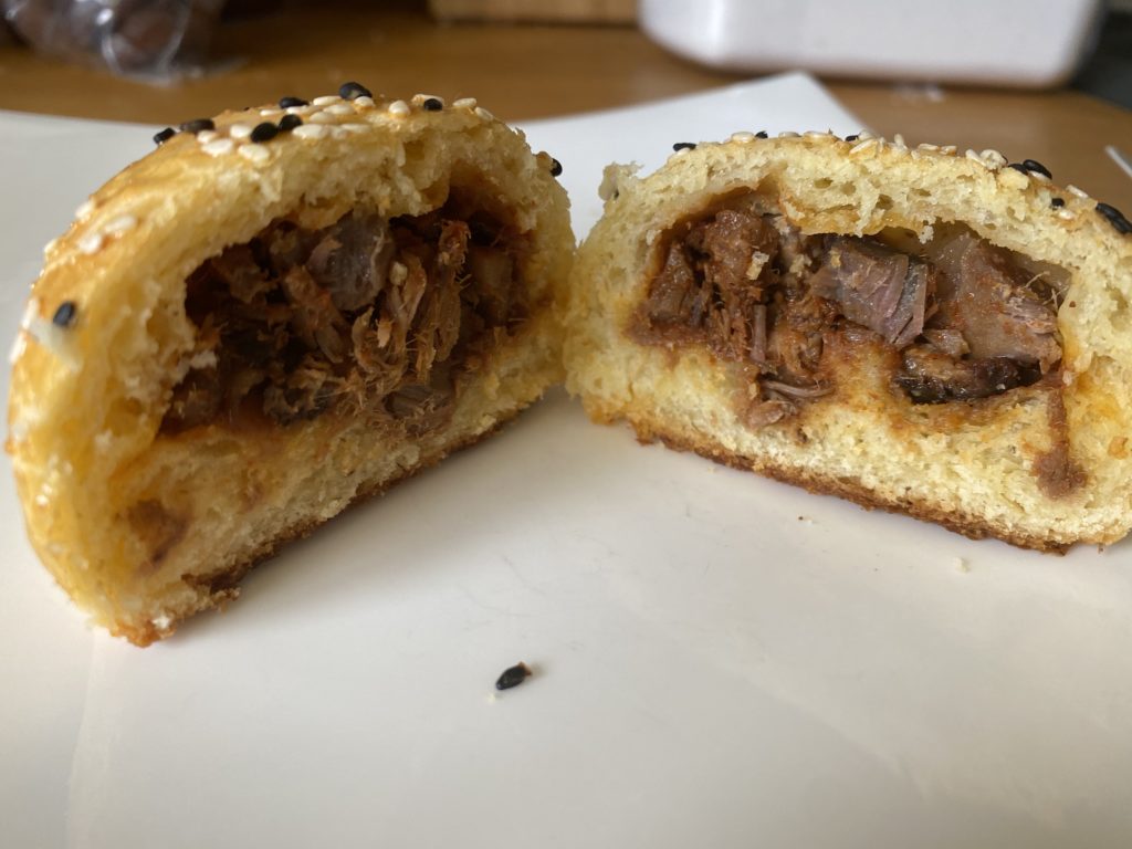 Bao, cut in half so you can see the pork filling inside.